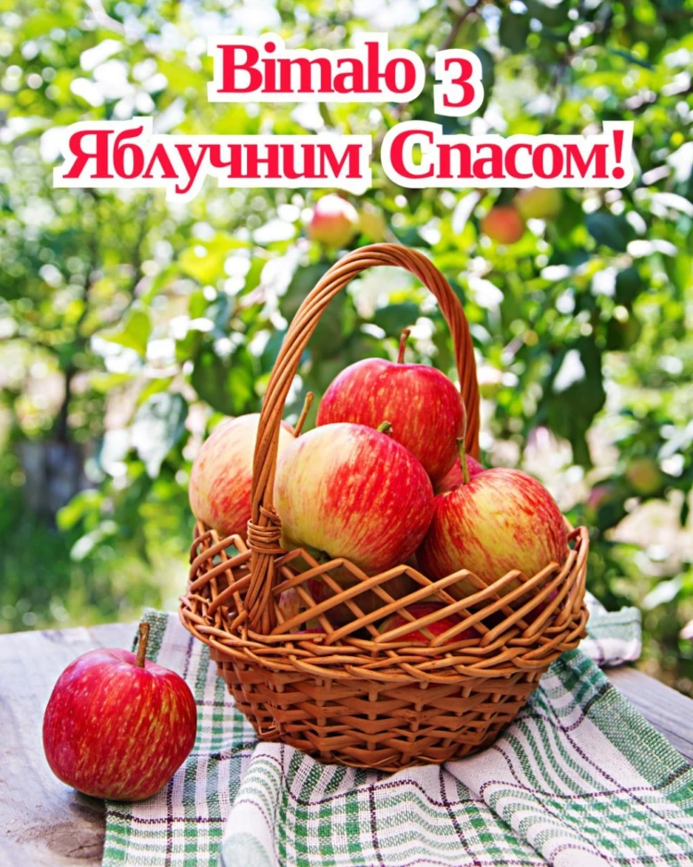 Корзина з яблуками на столі в саду. Привітання з Яблучним Спасом!