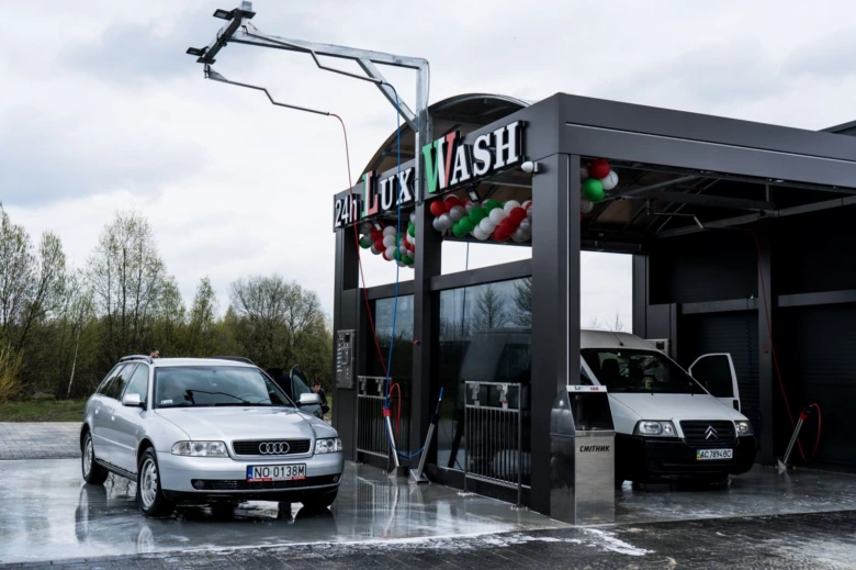 Срібний автомобіль та вантажівка на мийці під відкритим небом