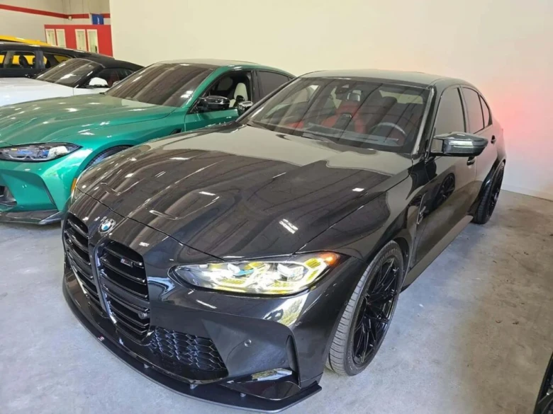 Чорний автомобіль BMW серед інших авто в салоні